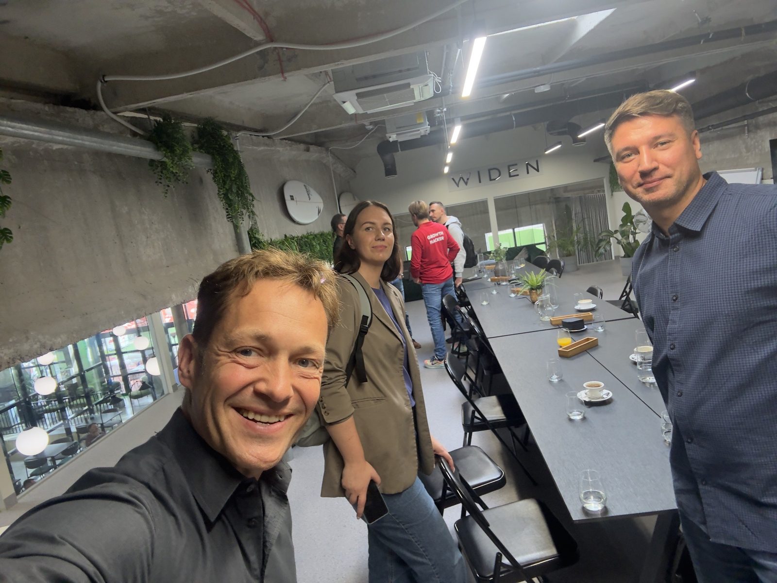 Three guests smiling for a selfie next to the brunch table after the conversation